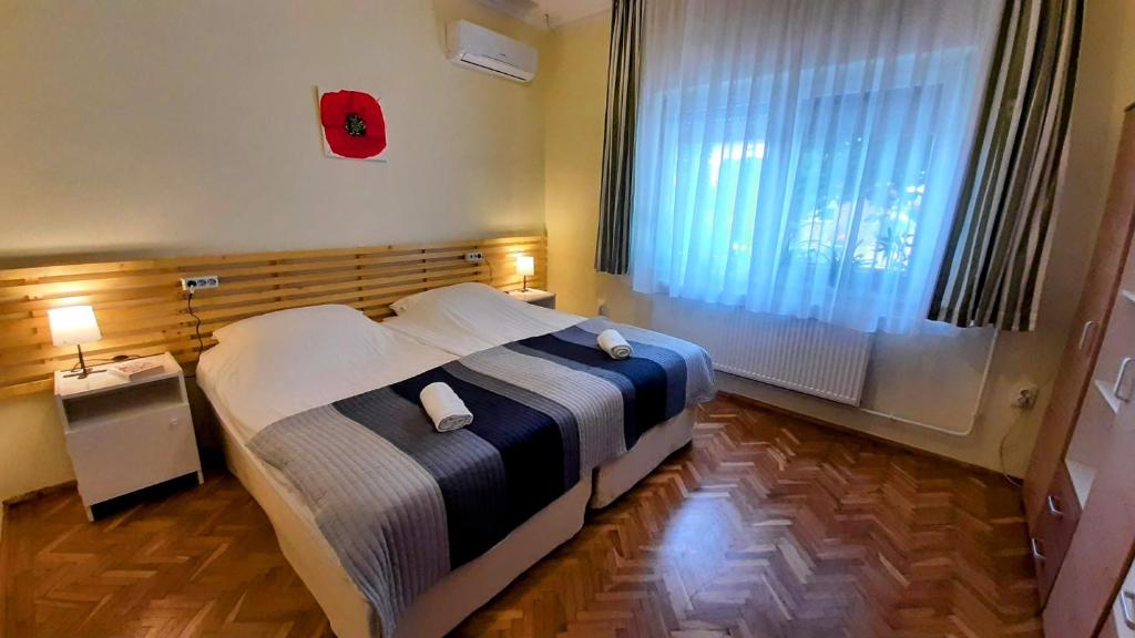 ein Schlafzimmer mit einem Bett und einem großen Fenster in der Unterkunft MIMO APARTMAN in Hajdúszoboszló