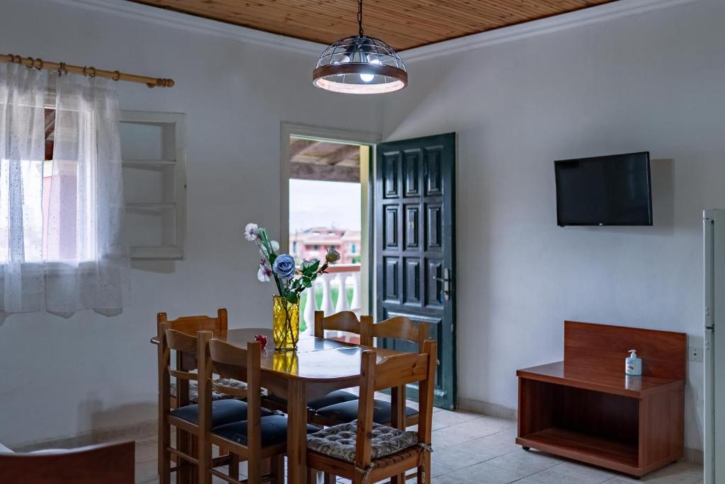 a dining room with a table and chairs and a television at Katerina Studios & Apartments in Sidari