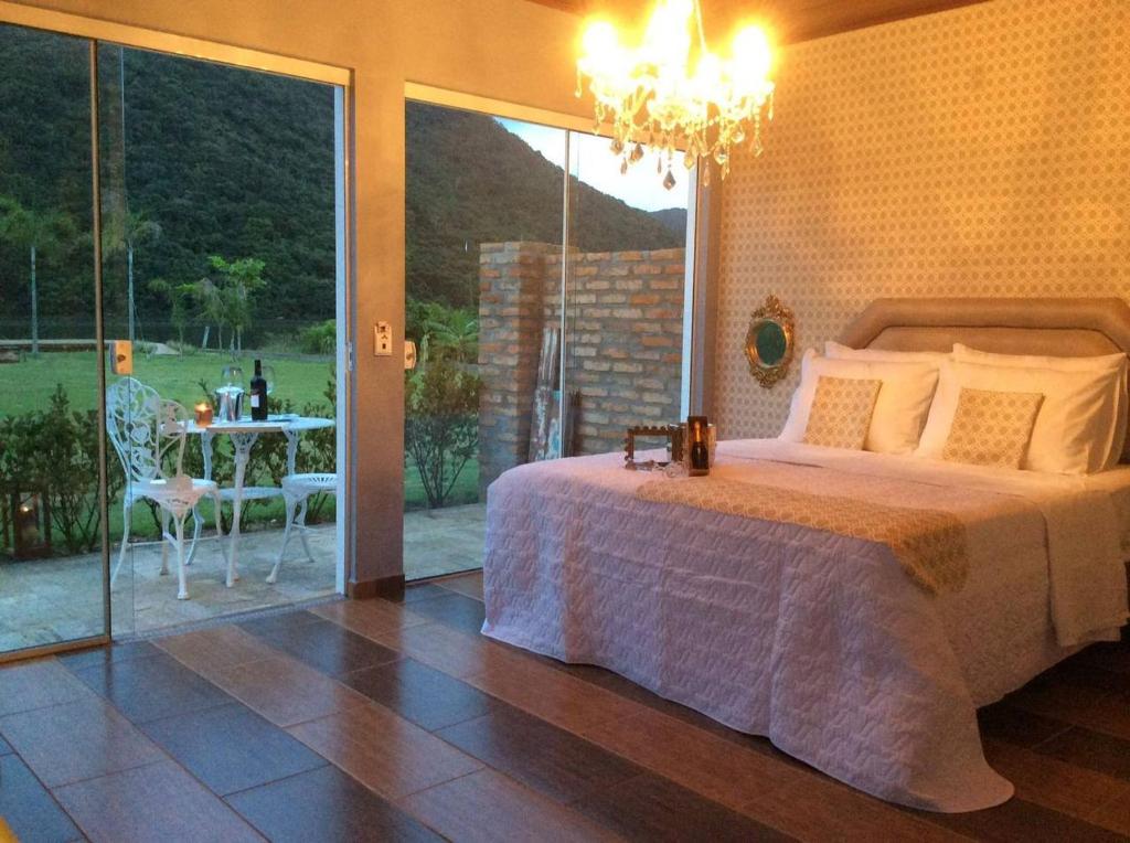 a bedroom with a bed and a view of a patio at Villa Amore Floripa in Florianópolis