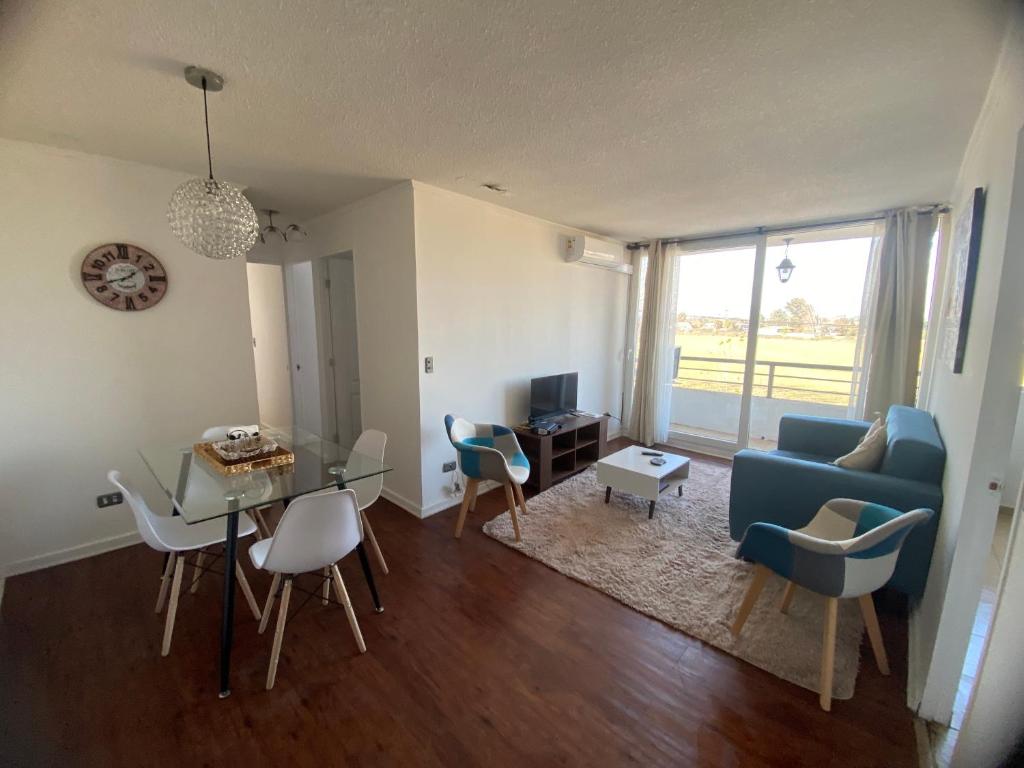 ein Wohnzimmer mit einem blauen Sofa und einem Tisch in der Unterkunft Apartamento boldo Curicó in Curicó