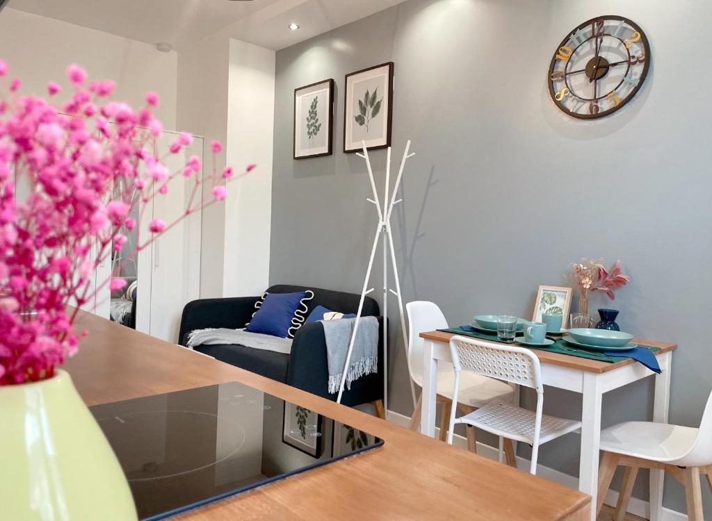 uma cozinha e sala de estar com mesa e cadeiras em Le nid doux - proche Paris & métro em Villejuif