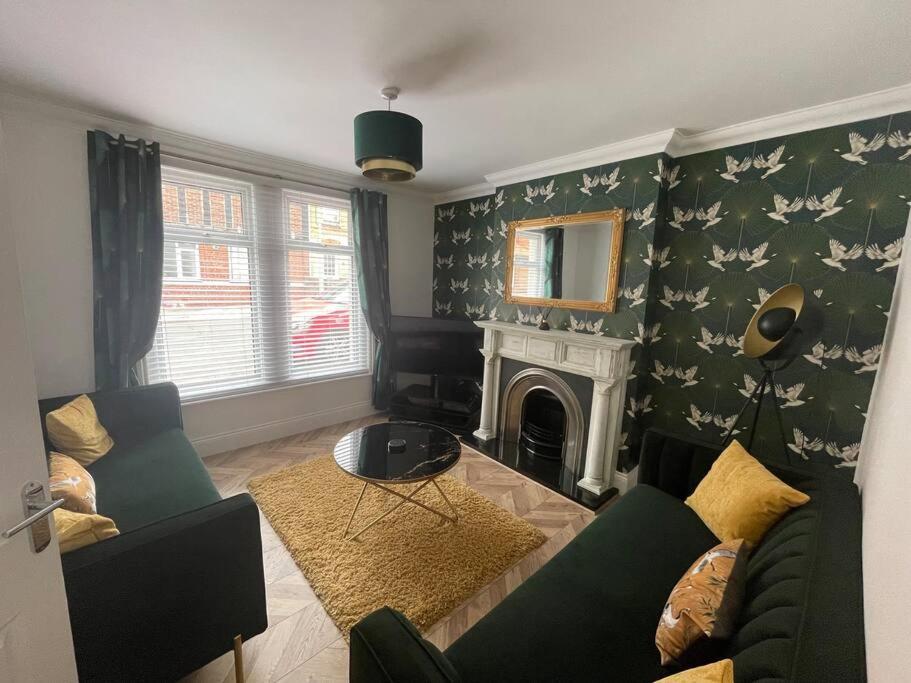 a living room with a couch and a fireplace at Taylor’s Retreat in Radipole