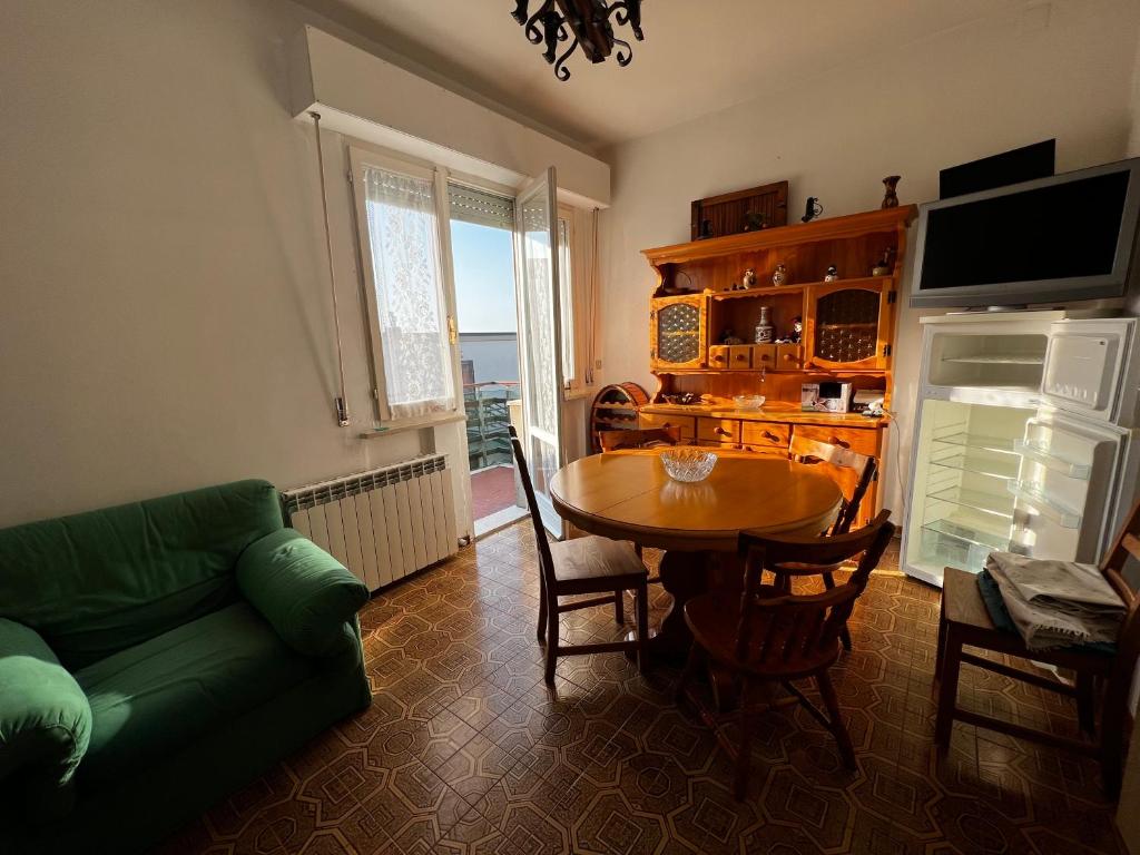 een woonkamer met een tafel en een groene bank bij Acqua e Sale in Marina di Montemarciano