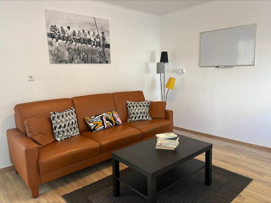 a living room with a brown couch and a table at Zur Guten Stube - Self Check In- 