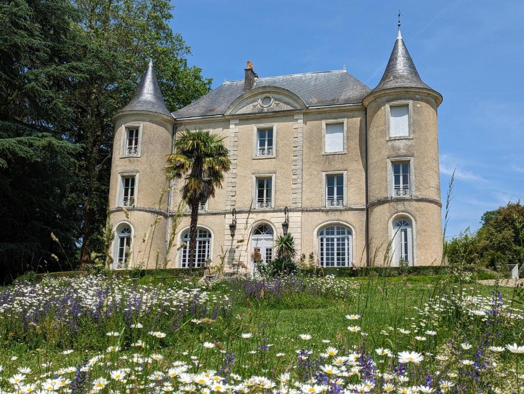 stary dom z polem kwiatów przed nim w obiekcie Château de Lavaud w mieście Montbron