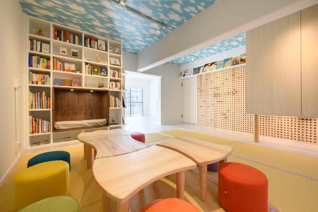 a room with a table and chairs and bookshelves at Ehon Hotel in Nara