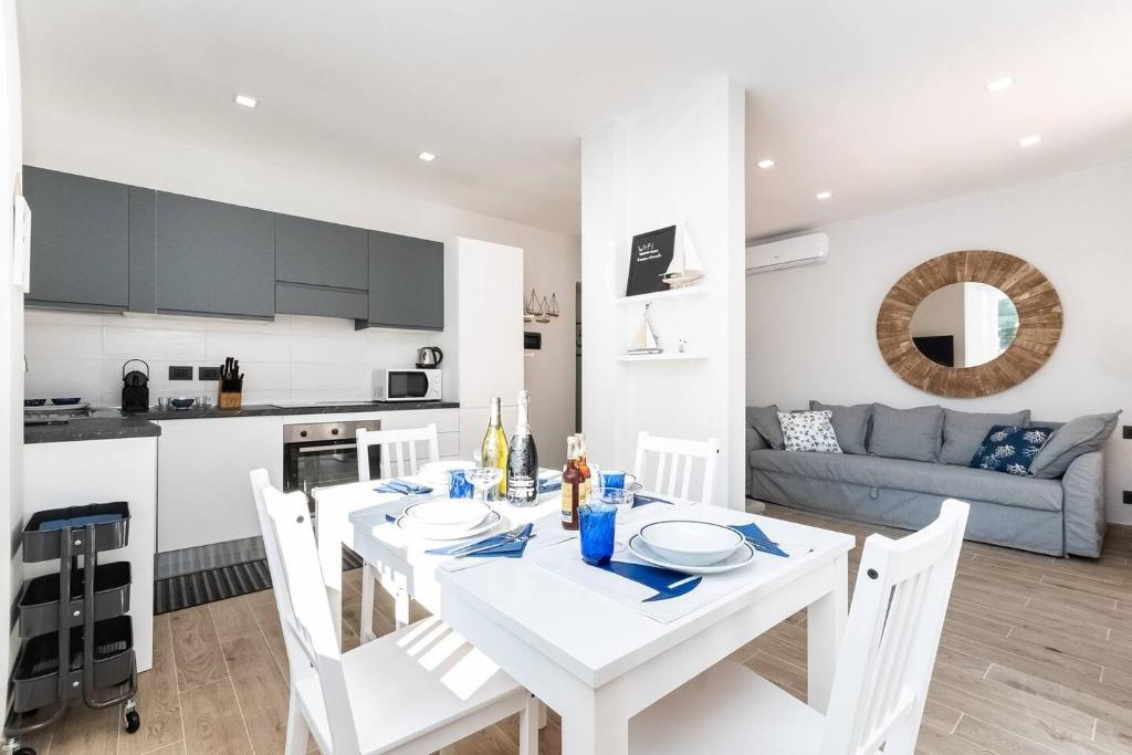 uma cozinha e uma sala de jantar com uma mesa branca e cadeiras em Cozy Terrace in Portofino [Free Parking] em Portofino