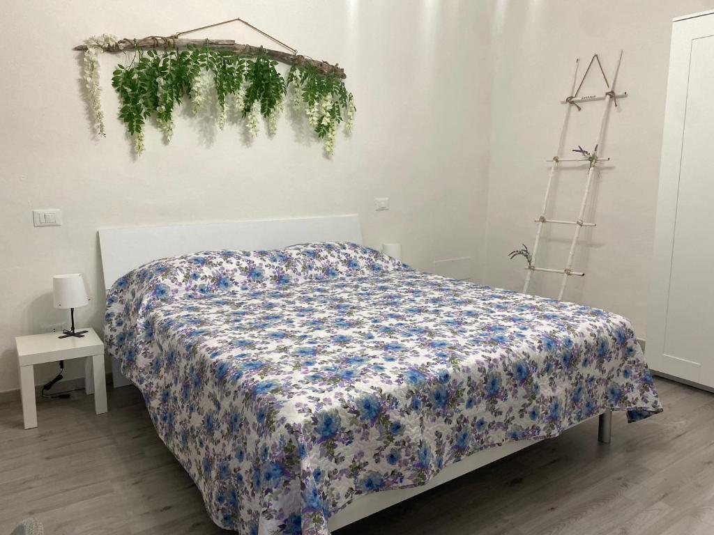 1 dormitorio con 1 cama con manta de flores en La Petite Maison, en Usigliano