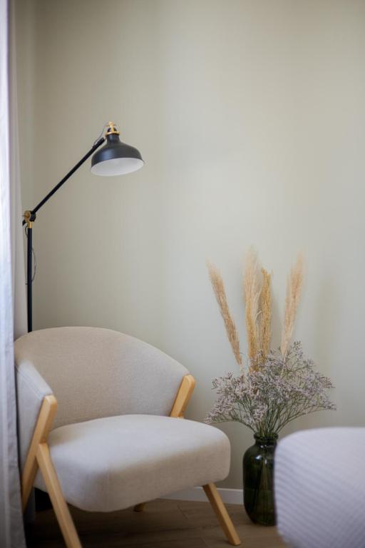 a room with a chair and a lamp and a vase of flowers at Luxury Rooms Zara&Ane in Split