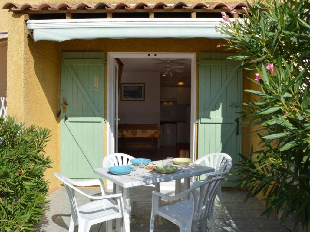 une table et des chaises devant une maison dans l'établissement Pavillon à Narbonne Plage, 6 couchages, terrasse, à 300m de la plage, parking, ménage inclus - FR-1-229B-24, à Narbonne