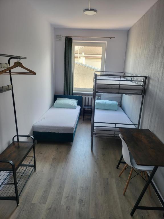 a room with two bunk beds and a table at Rooms4Rest Wiertnicza - Private rooms for tourists - ATR Consulting Sp, z o,o, in Warsaw