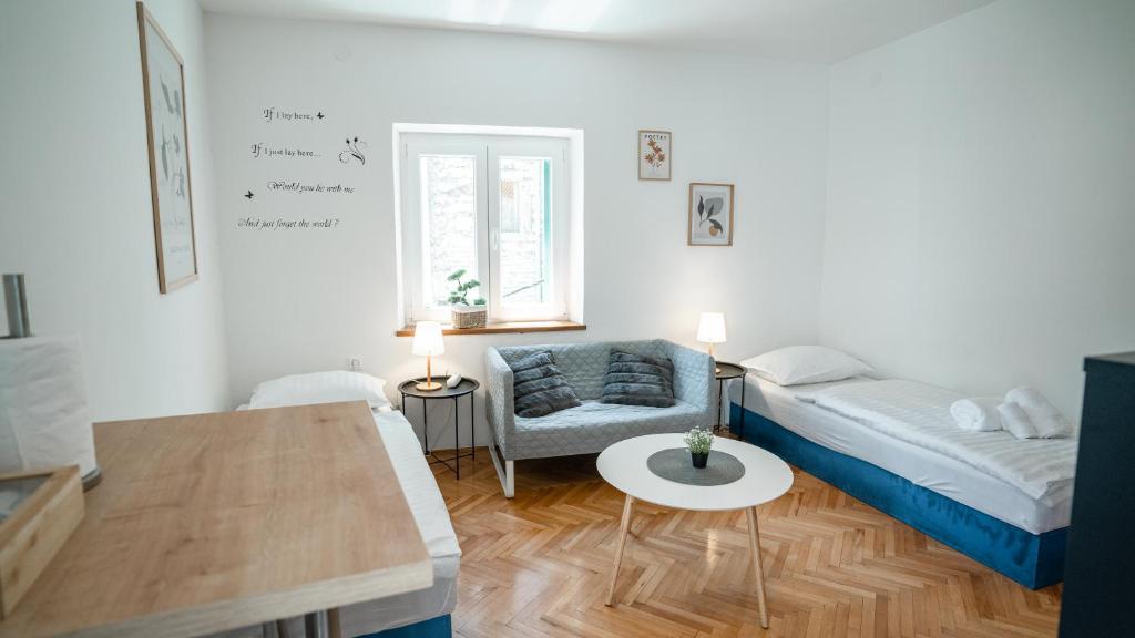 una pequeña sala de estar con cama y mesa. en House Gorica, en Šibenik