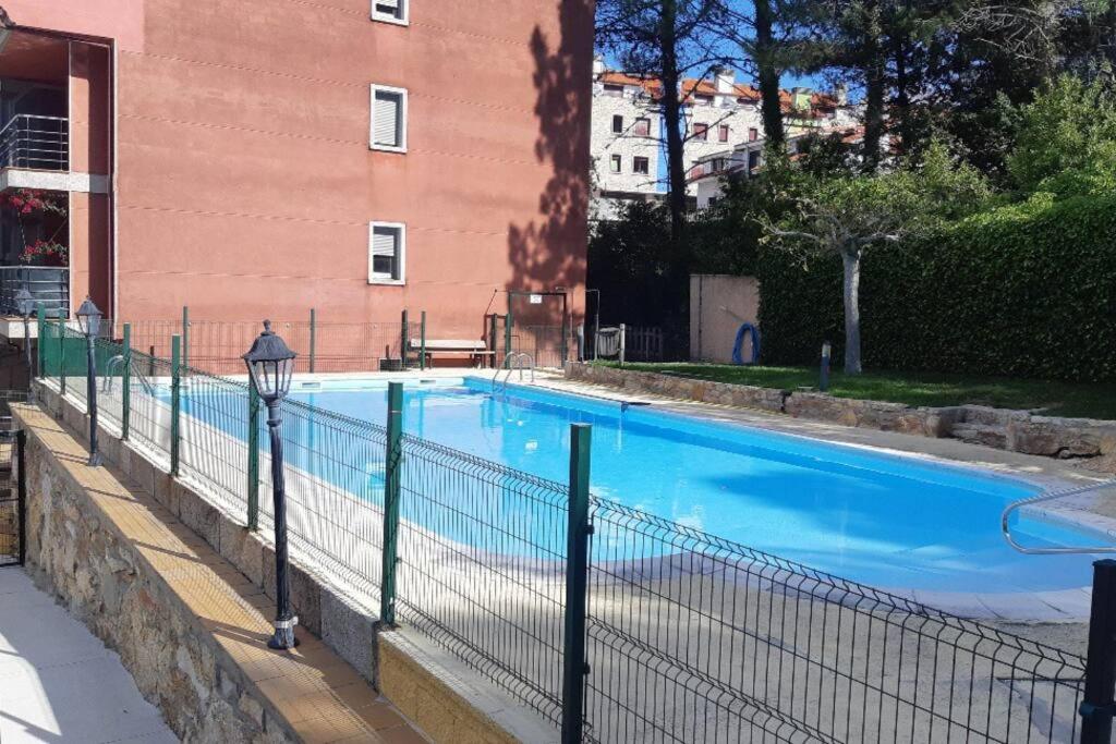 a large blue swimming pool next to a building at Casa Antonia Portosín in Portosin