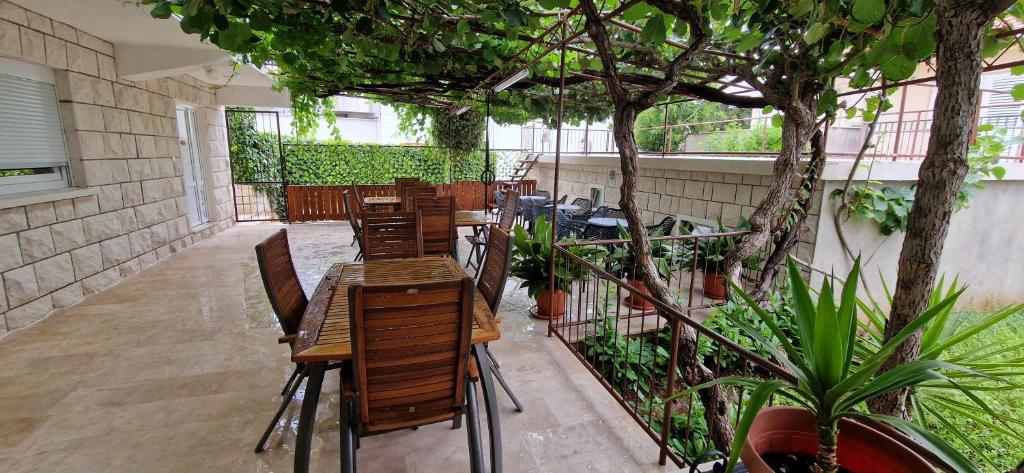 a patio with a table and chairs and a tree at Palute in Supetar