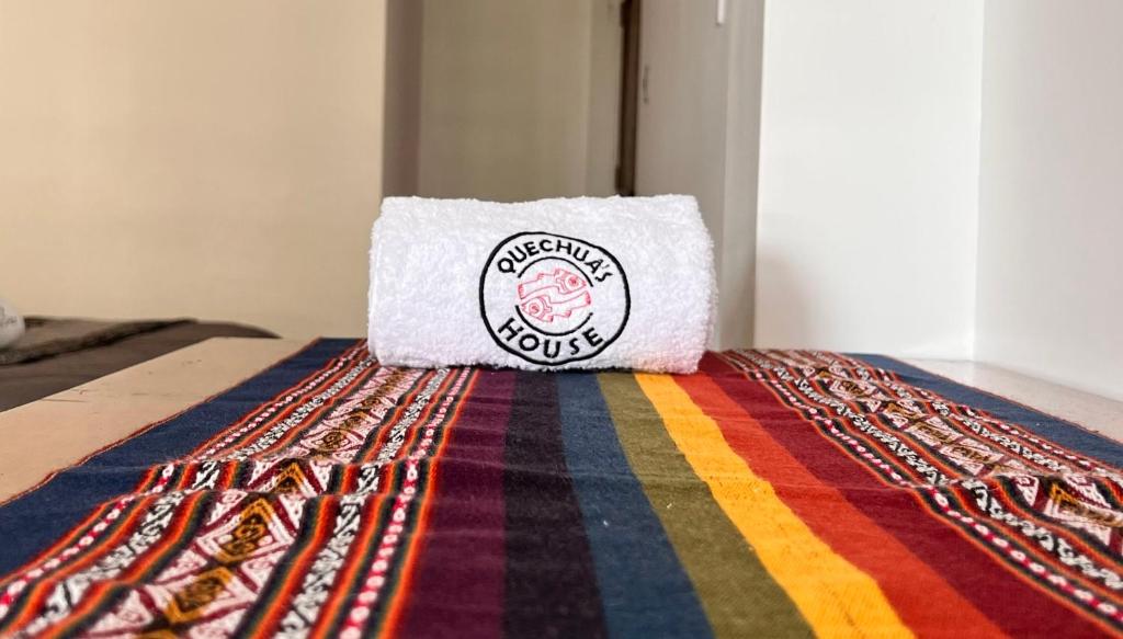 Una toalla encima de una alfombra colorida. en QUECHUA´S HOUSE Hostal & Coffee, en Machu Picchu