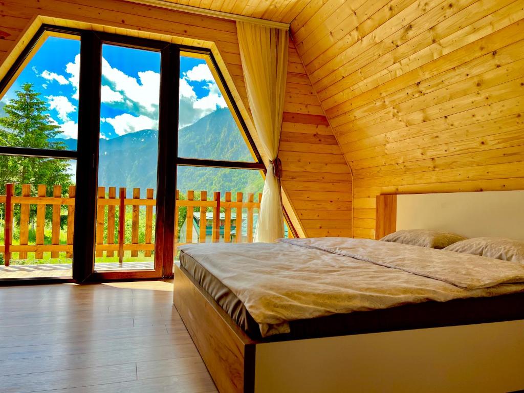 ein Schlafzimmer mit einem Bett und einem großen Fenster in der Unterkunft Villa Dardania in Peja
