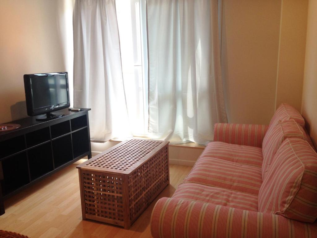 Televízia a/alebo spoločenská miestnosť v ubytovaní Apartaments Muntaner I
