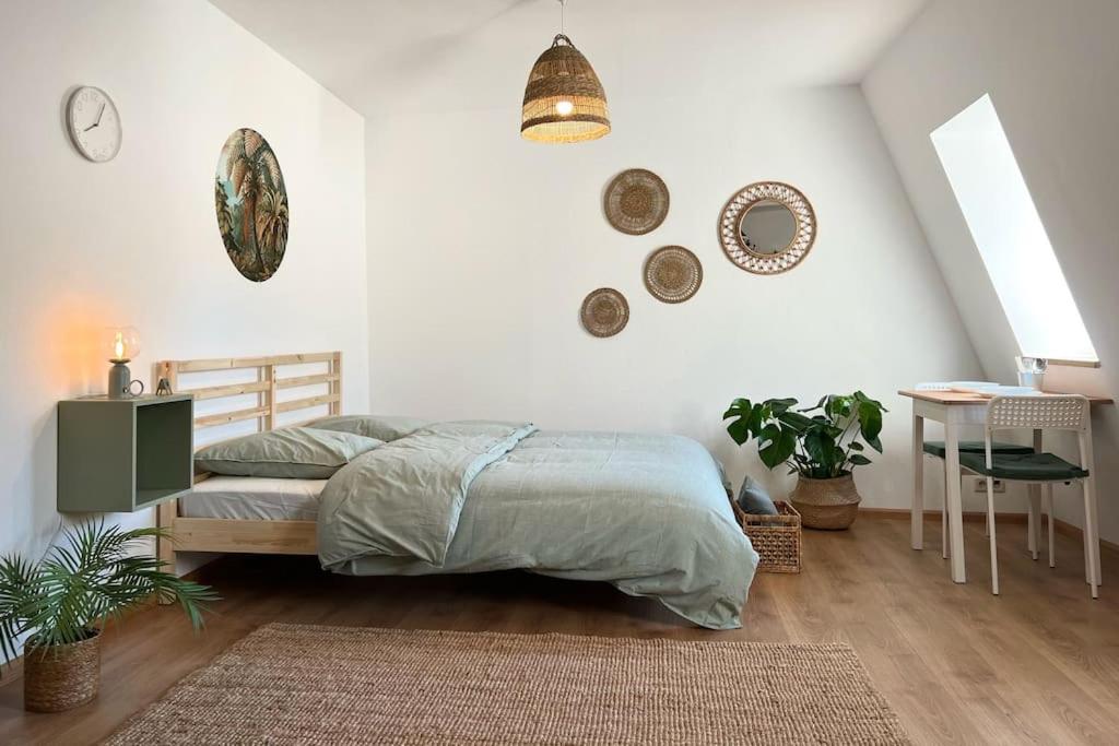 - une chambre avec un lit et une table avec une chaise dans l'établissement “Sweet boho penthouse” in city center, à Lahr/Schwarzwald