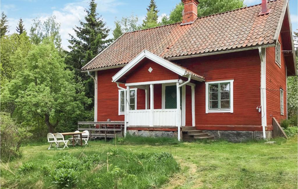 een rood huis met twee stoelen ervoor bij 3 Bedroom Nice Home In Norrtlje in Norrtälje