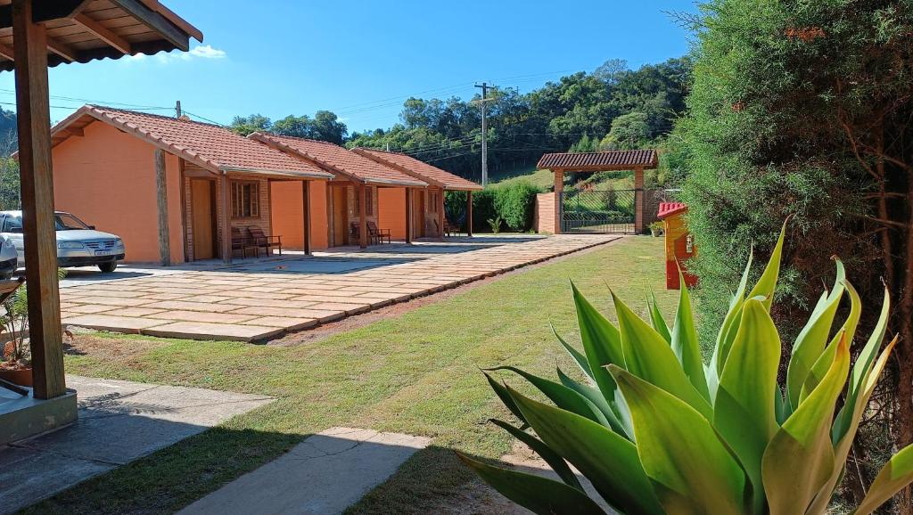 a house with a patio and a yard at Pousada Estrelícia in Cunha