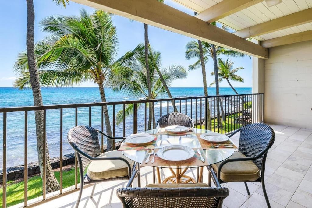 una mesa y sillas en un balcón con vistas al océano en New Top Hawaii Oceanfront 2BR/2BR with White Sand Beach-Kona Bali Kai 206 en Kailua-Kona