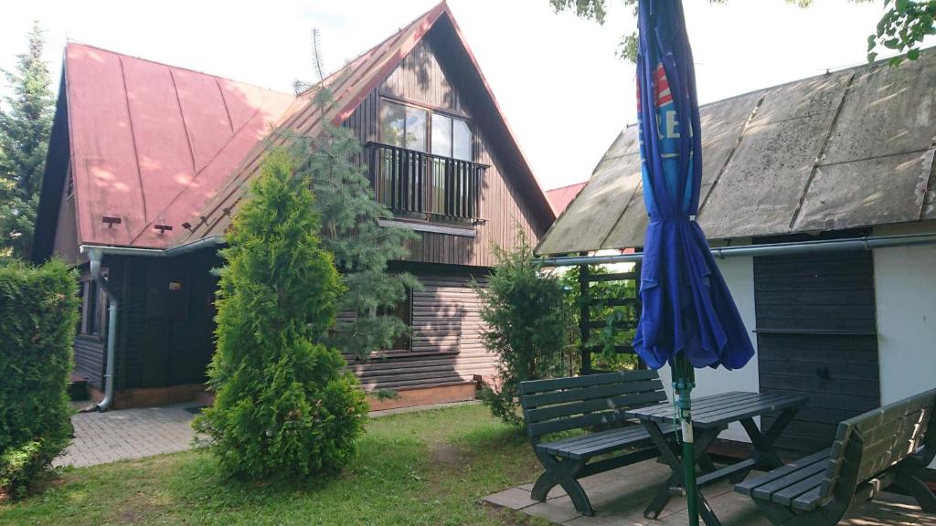 una casa con un banco y una sombrilla en el patio en Chata č.6, en Zlaté Hory