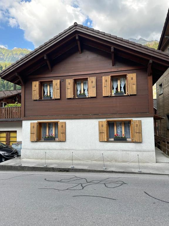 a house with wooden shuttered windows on a street at Chalet Lauterbrunnen in Lauterbrunnen