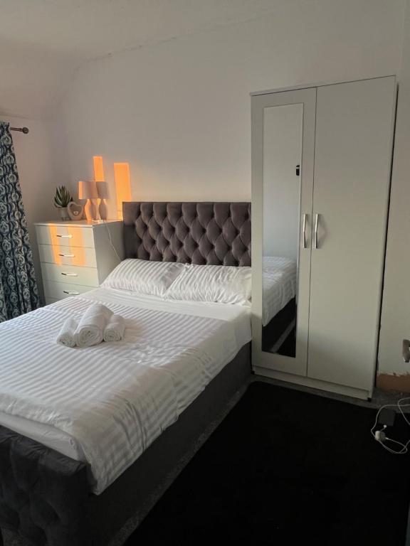 una camera con un grande letto con testiera di Arely House Rooms With Shared Bathroom a Arley