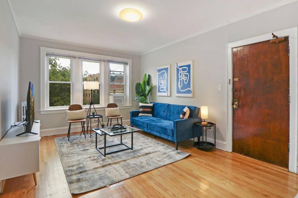 ein Wohnzimmer mit einem blauen Sofa und einem Tisch in der Unterkunft Spacious & Inviting 1BR Apt in Chicago - Cullom B2 in Chicago
