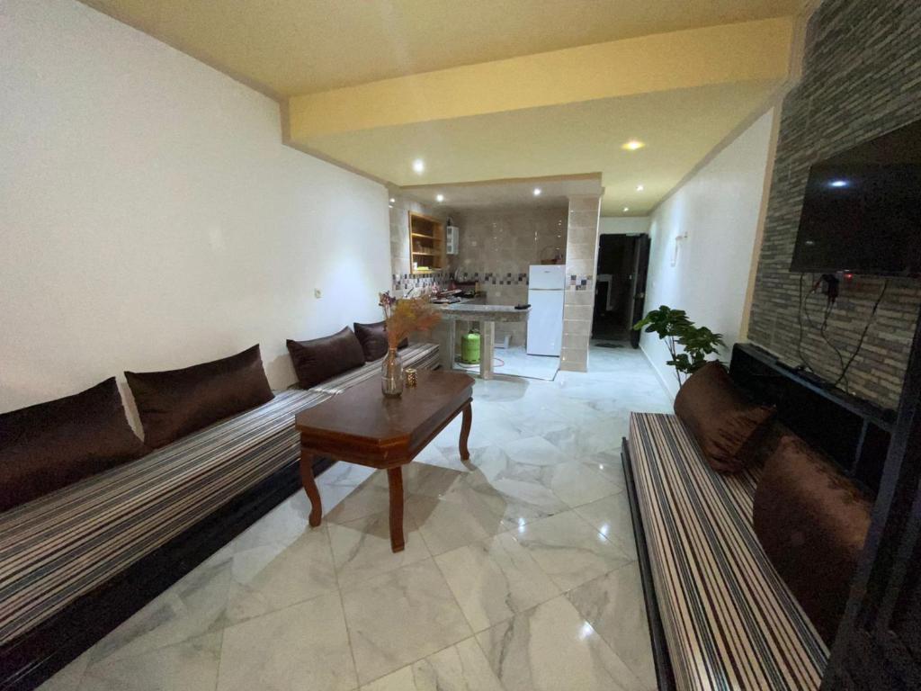 - un salon avec un canapé et une table dans l'établissement Studio Apartment By The Beach, à Tanger