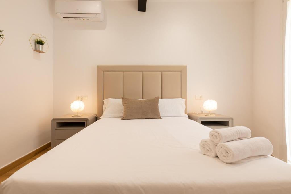 una camera da letto con un grande letto bianco con asciugamani di La Terracita de Bisagra a Toledo