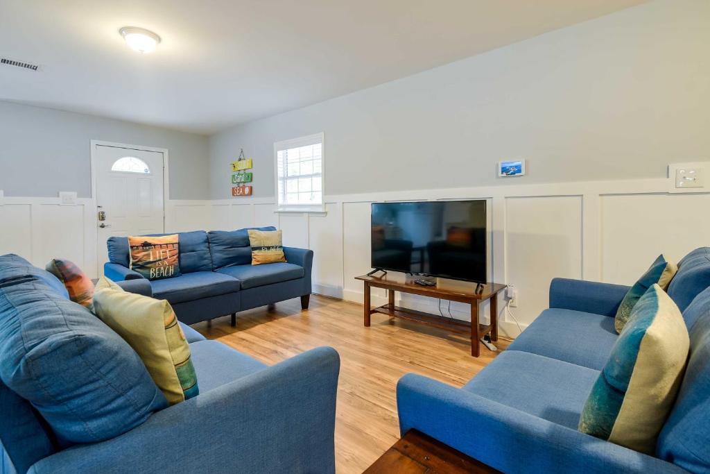 a living room with two blue couches and a tv at Summertime Escape with Grill Walk to Atlantic Beach in Myrtle Beach