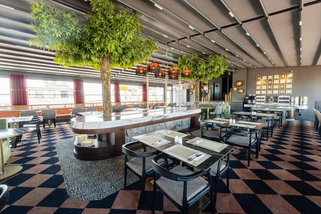 restauracja ze stołami, krzesłami i drzewem w obiekcie Hotel Yigitalp Istanbul w Stambule