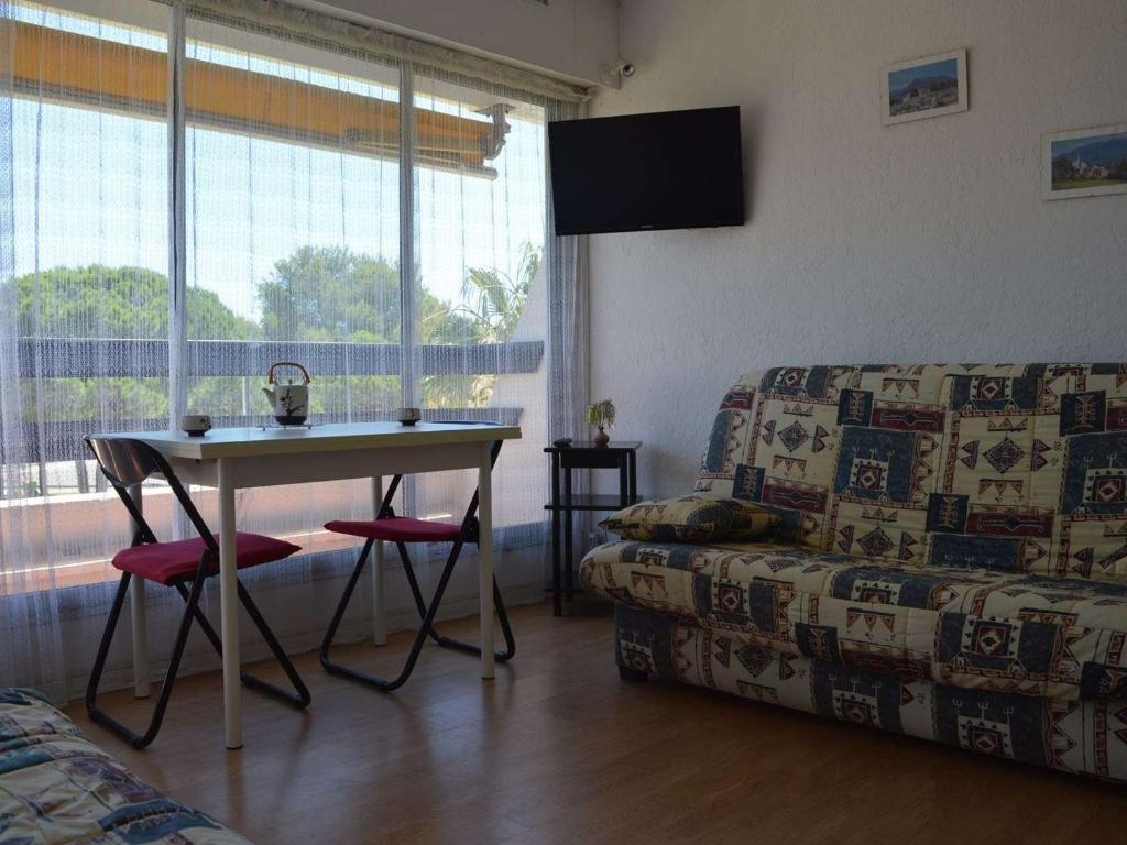 un salon avec une table et un canapé dans l'établissement Studio cabine 4 pers. avec balcon, piscine, parking, accès direct plage - Grau-du-Roi - FR-1-250-157, au Grau-du-Roi
