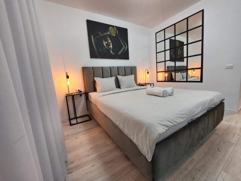 1 dormitorio con 1 cama grande y espejo en Elite Studio Militari Residence, en Chiajna