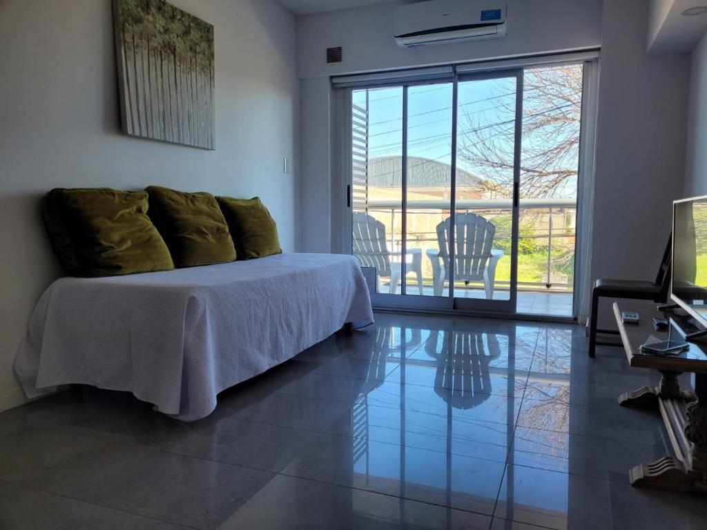 Schlafzimmer mit einem Bett und einer Glasschiebetür in der Unterkunft Departamento céntrico villa ramallo in Ramallo