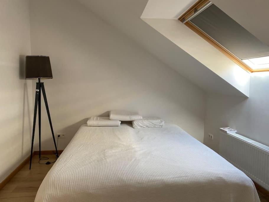 uma cama branca num quarto com uma janela em Spacious app/Antwerp city center #003 em Antuérpia
