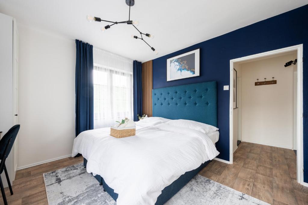 Penzion Mezi buky في شريبسكا: غرفة نوم بجدران زرقاء وسرير كبير
