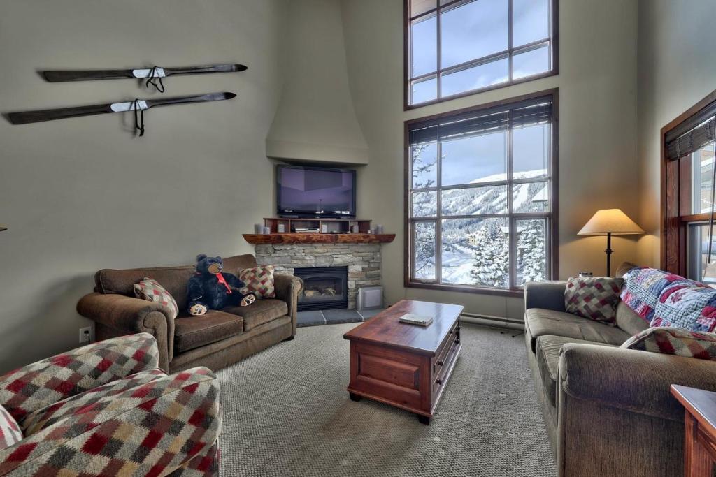 a living room with two couches and a fireplace at Trappers Landing #27 By Bear Country in Sun Peaks