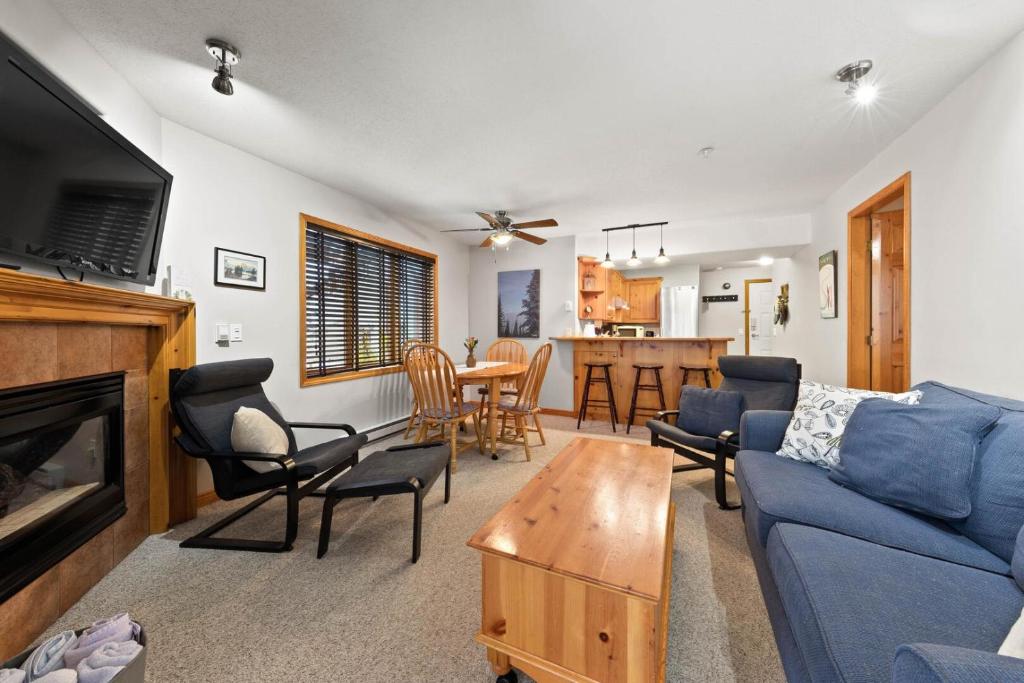 a living room with a blue couch and a table at Snow Creek Village #37 By Bear Country in Sun Peaks