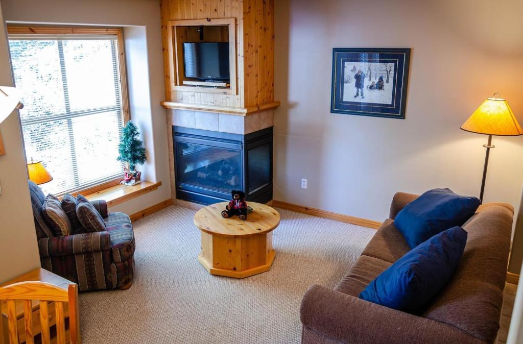 a living room with a couch and a fireplace at Crystal Forest #11 By Bear Country in Sun Peaks