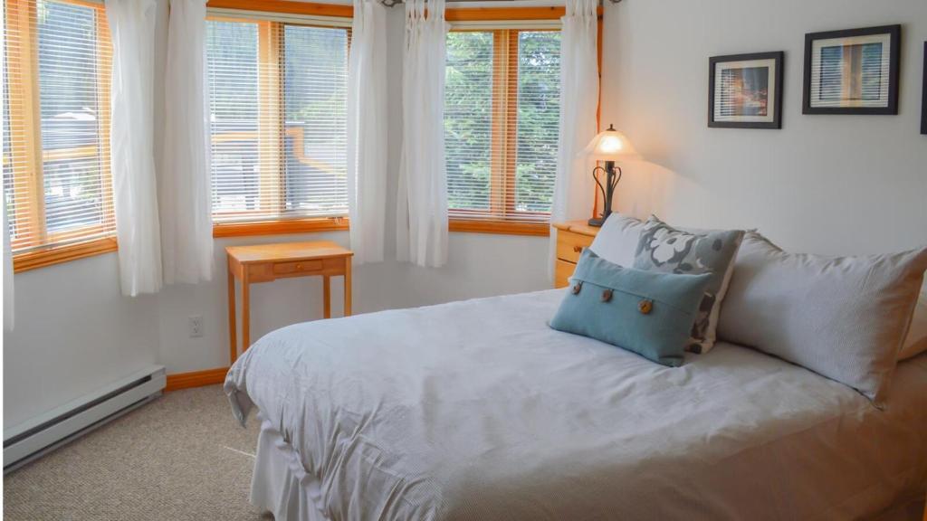 a bedroom with a bed with a blue pillow on it at Snow Creek Village #49 in Sun Peaks