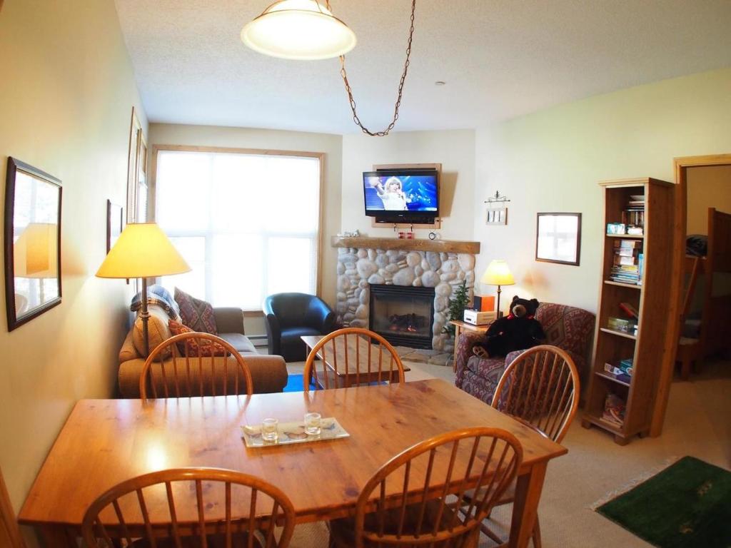 サンピークスにあるCrystal Forest #53 By Bear Countryのリビングルーム(テーブル、椅子、暖炉付)