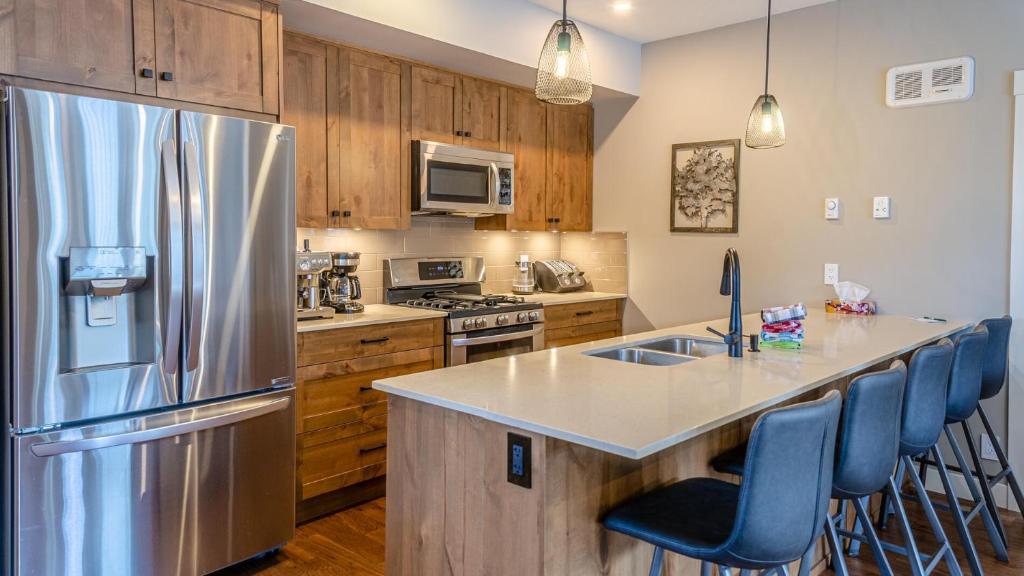 a kitchen with a stainless steel refrigerator and wooden cabinets at Echo Landing #05 by Bear Country in Sun Peaks