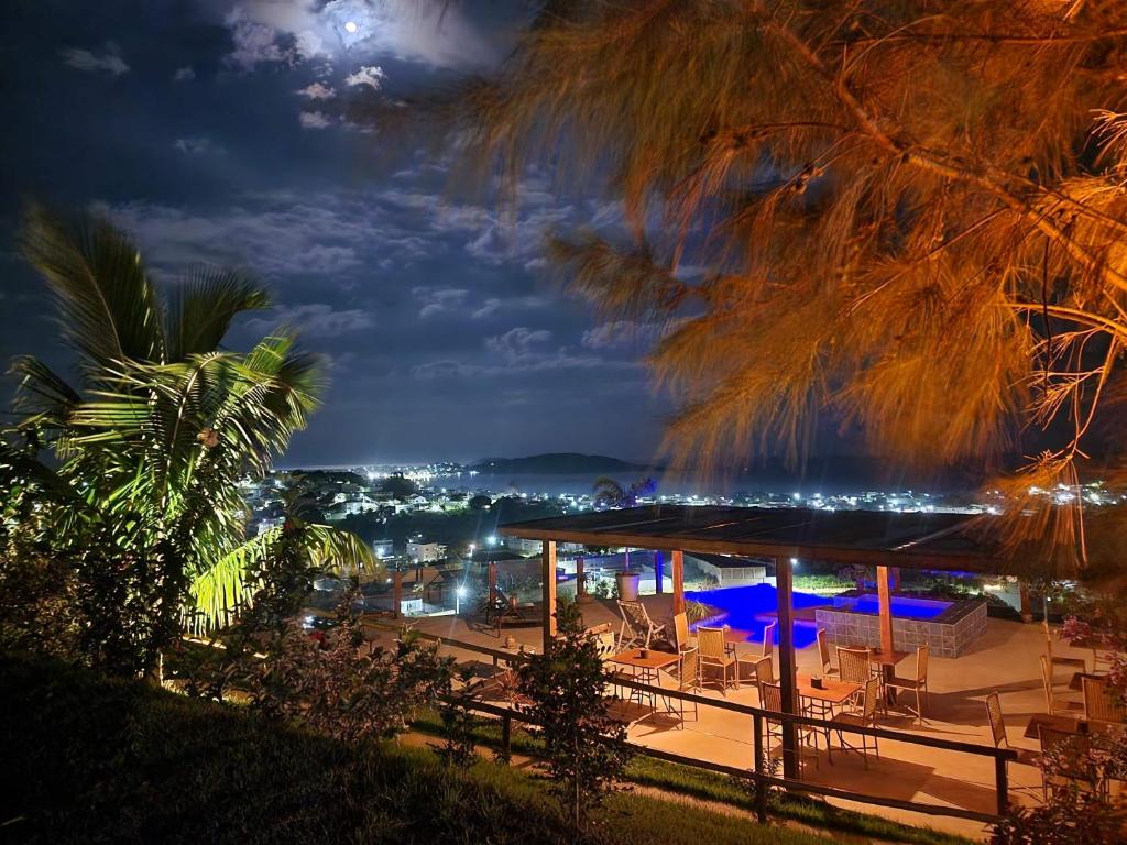 a pavilion with tables and chairs at night at Terraço in Guarapari