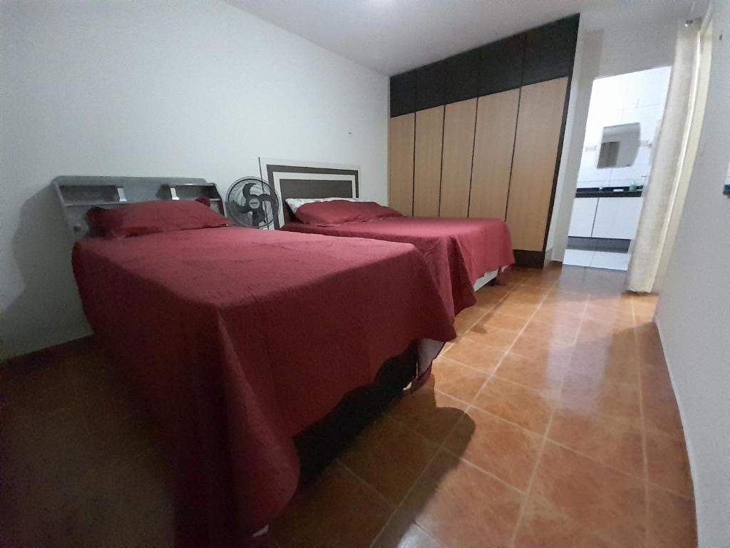 2 camas en una habitación con sábanas rojas. en FLAT FAMILIAR com garagem até 5 pessoas, en Campina Grande
