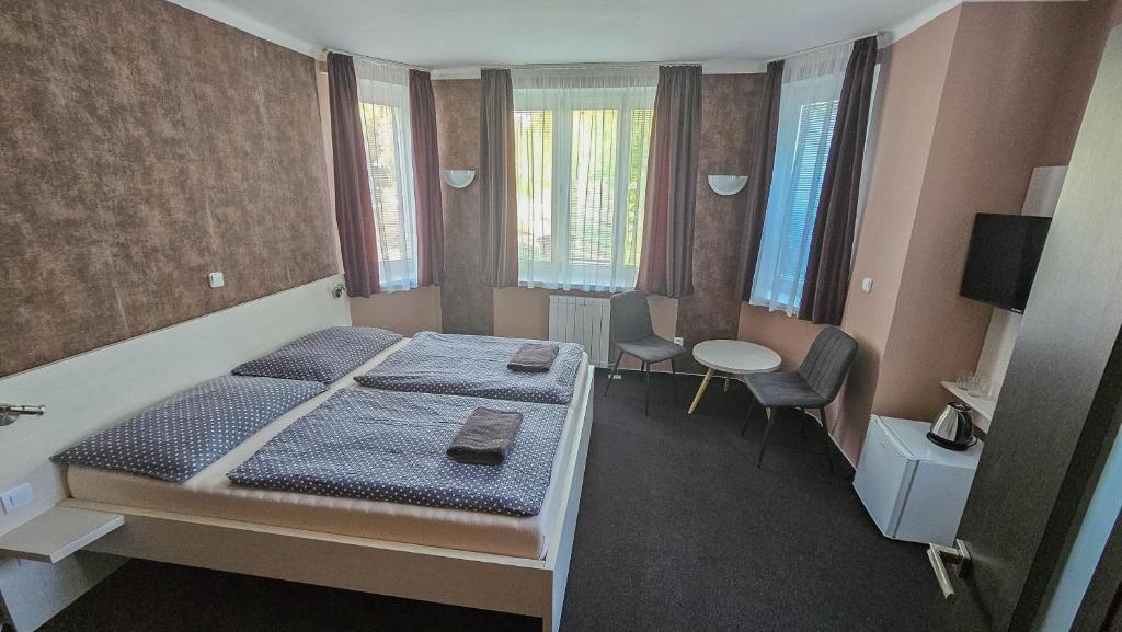 ein Schlafzimmer mit einem Bett und einem Tisch und Stühlen in der Unterkunft Almond in Teplice