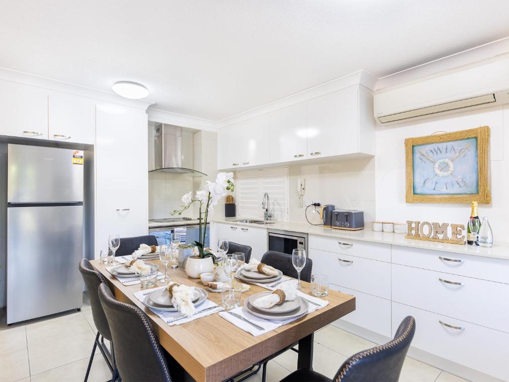 a kitchen with a table and chairs in a room at Spacious Newly Furnished 2bed Apartment in South Brisbane in Brisbane