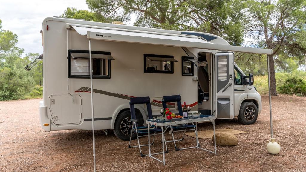 a white caravan with a table and chairs in it at Caravana Rustic Escapes in Valencia