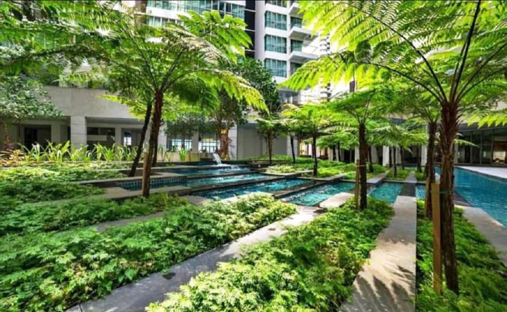 a courtyard with palm trees and a swimming pool at Luxury Regalia suites by adnan in Kuala Lumpur